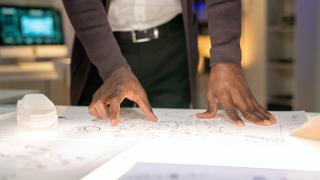 Close up of hands resting on planning documents