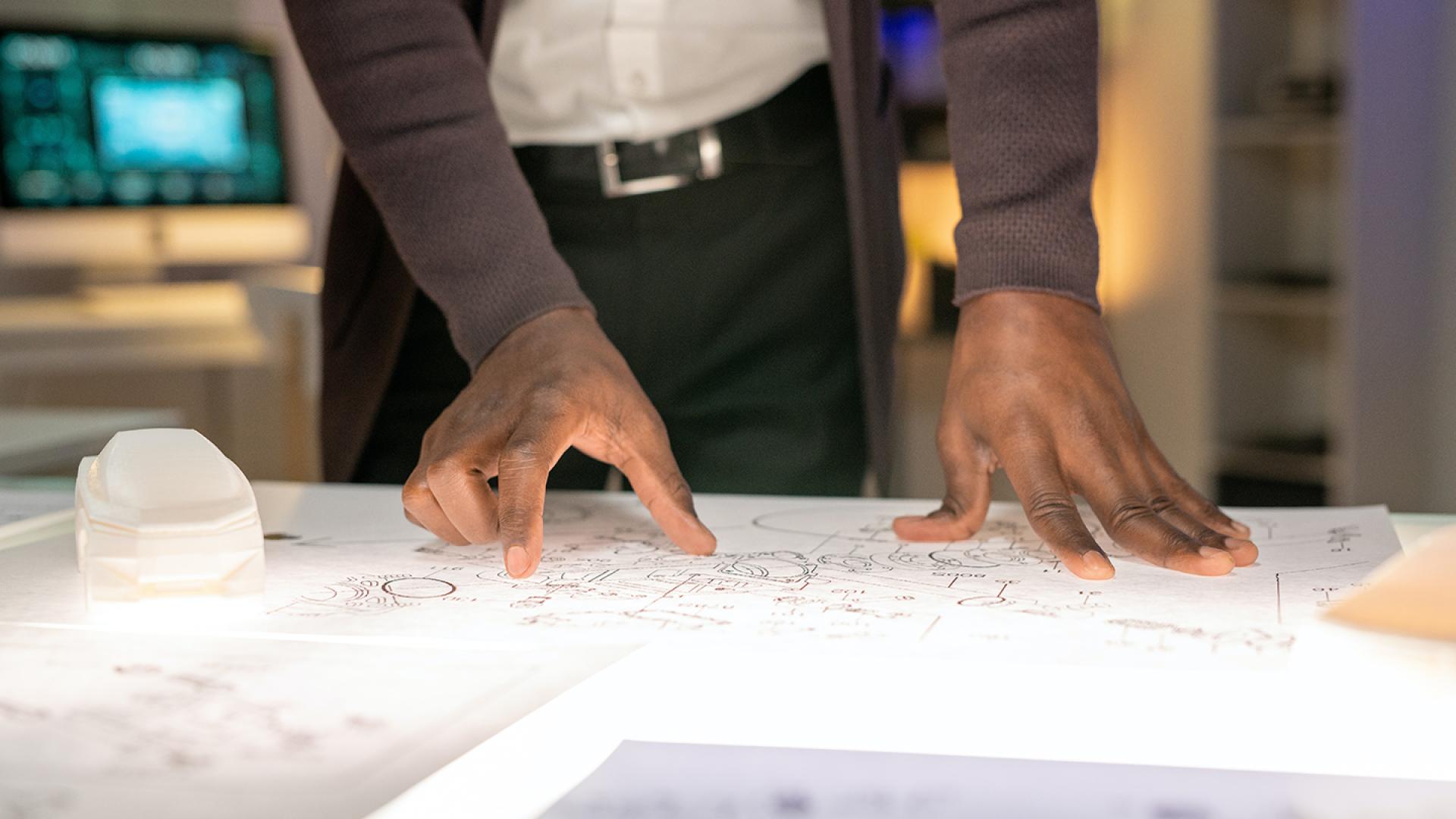 Close up of hands resting on planning documents